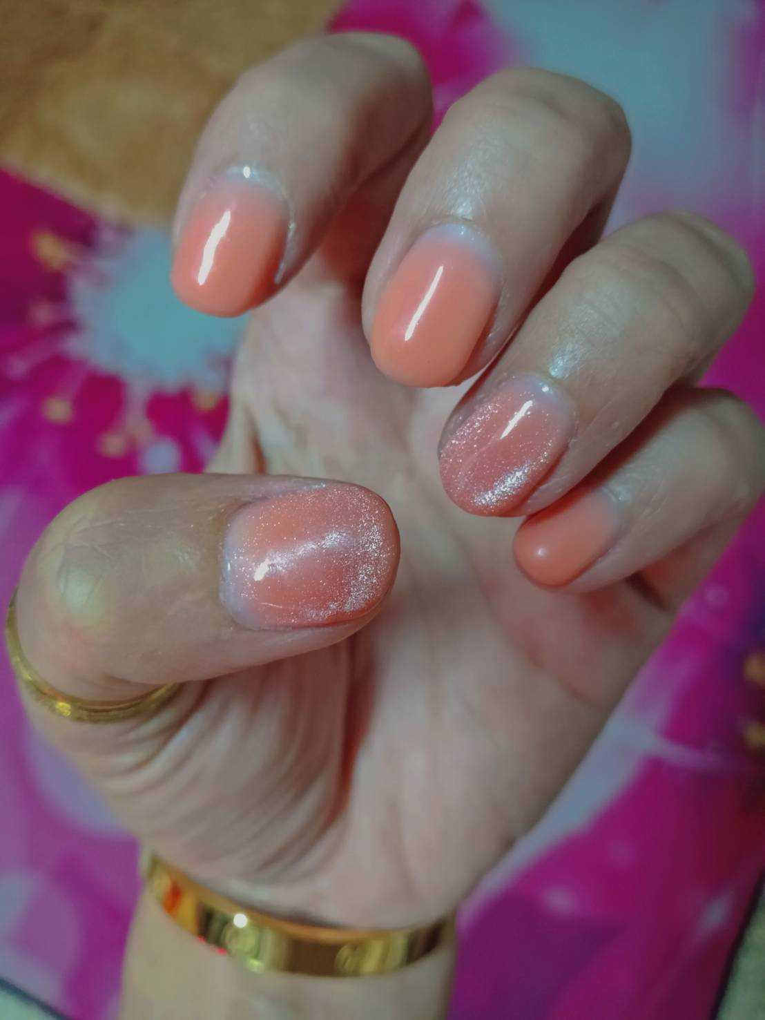ต่อเล็บสั้นทาด้วยสีส้มอมชมพูอ่อน และมีขอบสีขาวหนาที่โคนเล็บคล้ายเล็บชี้