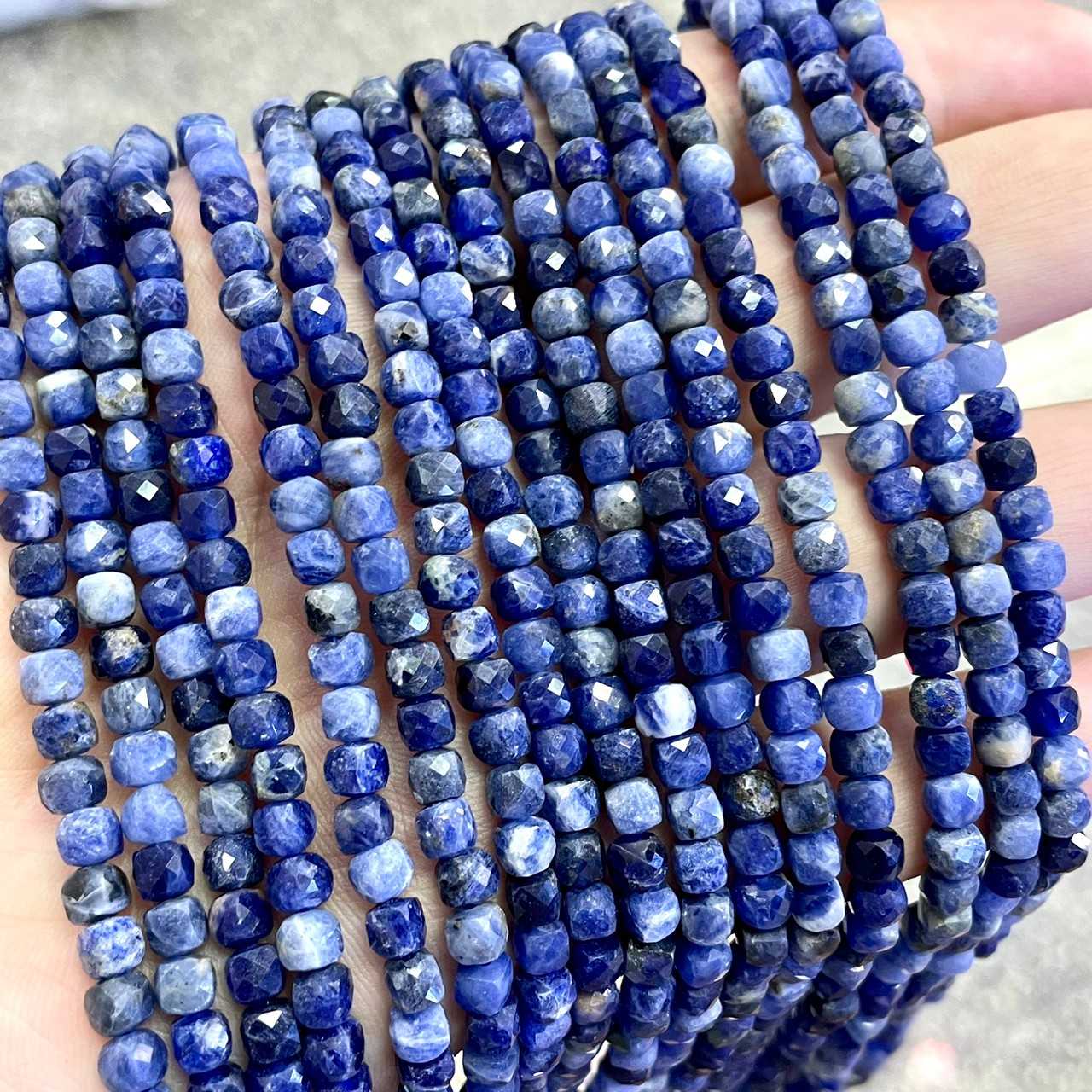 โซดาไลท์ สีเข้ม (Sodalite) ทรงลูกบาศก์ ประมาณ 4x4 mm เส้นยาว